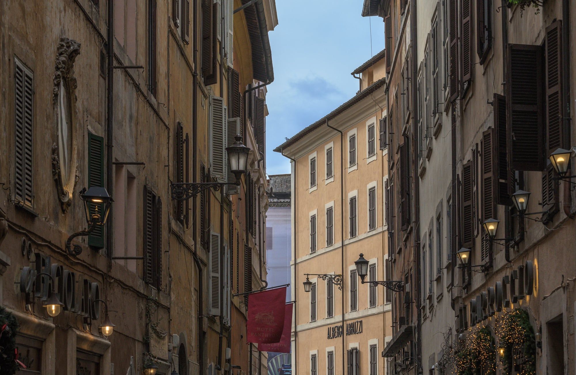 Hard Rock Cafe Rome entrance with the illuminated guitar sign on Via Vittorio Veneto at dusk
